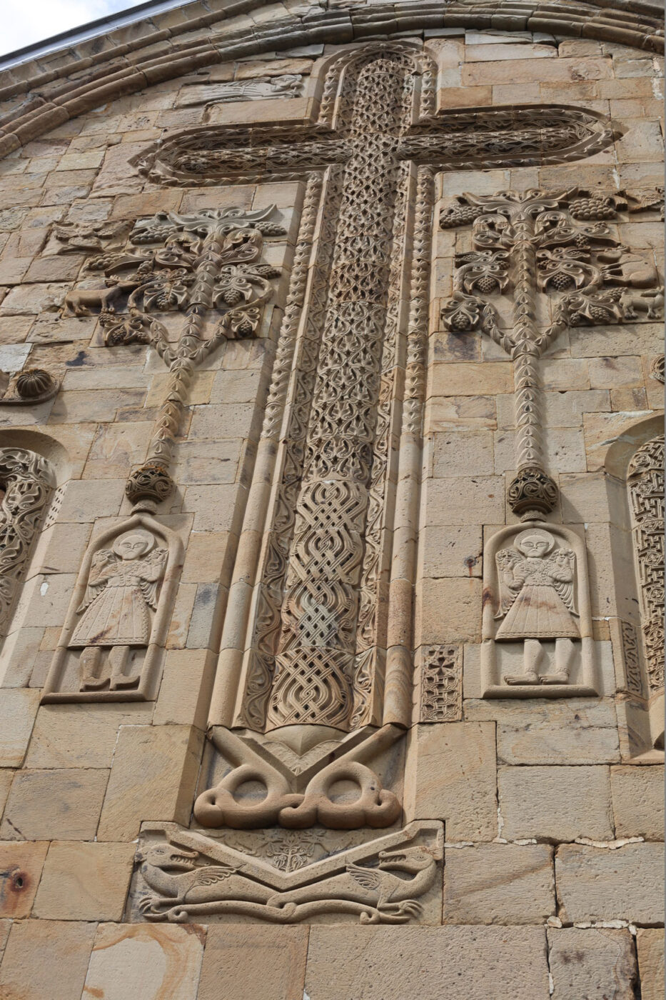 Prachtige versierd kruis met aan beide zijden de levensboom op de kerk van Ananuri